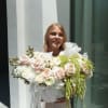 Woman holding a large bouquet of pale roses and white flowers