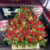 Large bouquet of red roses with a birthday balloon in a car trunk