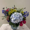 Mixed bouquet with blue hydrangea in a glass vase
