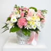 Pink and white mixed bouquet in a white basket with a pink ribbon
