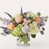 Bouquet of peach roses and hydrangeas in a clear glass vase