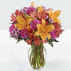 Bright orange lilies stand proud above a lush, rounded bouquet in this