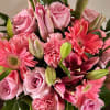 Pink roses, gerbera daisies, lilies, and carnations in a bouquet