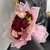 Bouquet of red roses and pink lilies wrapped in pink paper