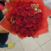 Bouquet of red roses wrapped in red paper with gold butterfly accents