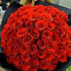 Large bouquet of red roses wrapped in dark paper