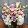 Pink roses and white hydrangeas in a square glass vase with calla lilies