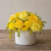 Bright yellow roses and sunny yellow chrysanthemums create an instant lift in