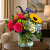 A burst of sunny color greets the recipient with bright pink roses