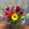 Mixed bouquet of roses, gerbera daisies, and snapdragons in a glass vase