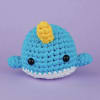 Crocheted blue whale plush with a yellow fin and white belly