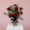 Bouquet of red roses in a glass vase with a black ribbon