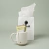 White mug gift set with tea packet and spoon in a paper bag