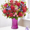 Bouquet of red and pink roses in a purple vase