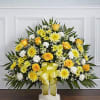 Yellow and white floral standing spray with a ribbon bow