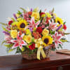 Basket arrangement of mixed flowers with a yellow ribbon