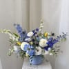 Blue and white floral arrangement in a light blue vase