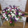 Large mixed bouquet of pink, purple, and white flowers on a table