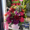 Pink and red mixed flower basket with a butterfly decoration