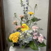 Floral arrangement with a yellow duck figurine in a black container