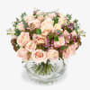 Blush pink roses arranged in a clear glass vase