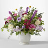 Mixed bouquet of pink, white, and purple flowers in a white vase