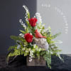 Silk red roses and white lily-of-the-valley in a rustic box with a cardinal figurine
