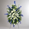 Standing floral spray with white lilies, roses, and blue flowers