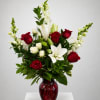 Red and white floral arrangement in a red glass vase