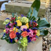 Colorful mixed bouquet in a clear glass vase with roses and alstroemeria