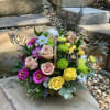 Mixed bouquet with roses, daisies, and bright mums in a basket