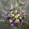 Large purple and white floral arrangement with lilies and roses