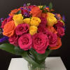 Bouquet of bright pink, orange, and yellow roses in a glass vase