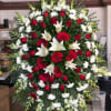 Large red and white funeral spray with roses, lilies, and gerbera daisies