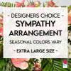 Sympathy arrangement with pink flowers and tropical leaves