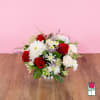 Bouquet of red and white flowers in a low silver vase