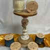 Assorted scented candles in glass jars on a decorative pedestal stand