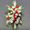 Standing floral spray with white daisies and red carnations on an easel