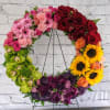 Colorful floral wreath on a metal stand with roses and sunflowers