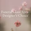 Pink floral funeral floor spray with soft blossoms on a pale background