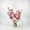 A soft and elegant vase arrangement featuring white hydrangea, peach stock, lege