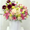 Pink and cream bouquet with lime accents in a white vase