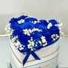 Blue roses with white baby's breath in a round white box