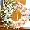 A lush wreath arranged for ceremony and remembrance, this flower arrangement features