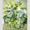 Large white and green floral arrangement with lilies and roses