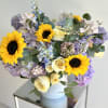 A lovely flower arrangement with soft purple and sky blue flowers, creamy