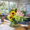 Bouquet of sunflowers and pink roses in a glass vase