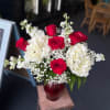 Vivid red roses and lush white hydrangeas with airy white fillers in