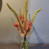 Tall mixed flower arrangement in a clear glass vase