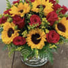 Bouquet of red roses and yellow sunflowers in a glass vase